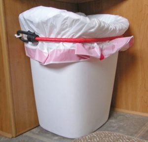 RV space saving idea: Bungee a trash can to the wall using two eye hooks