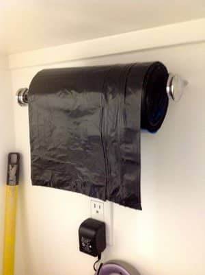 Store garbage bags on a paper towel holder