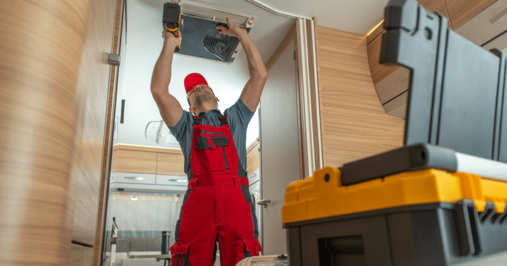 repairman fixing an rv air conditioning vent